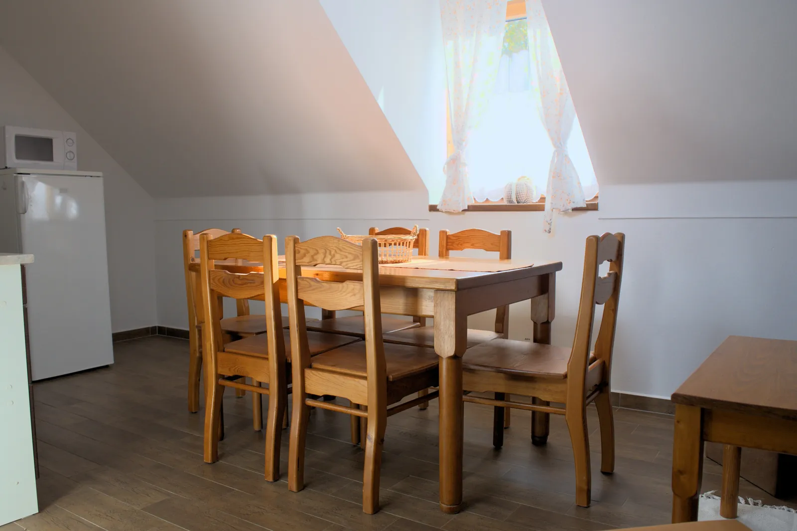 Jídelní stůl pod oknem v podkrovním Apartmánu 3