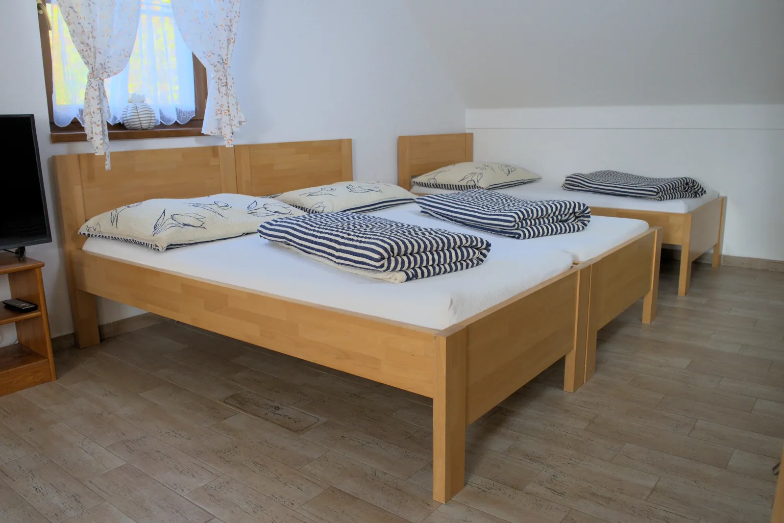 Podkrovní ložnice se třemi lůžky a televizí v Apartmánu 3
