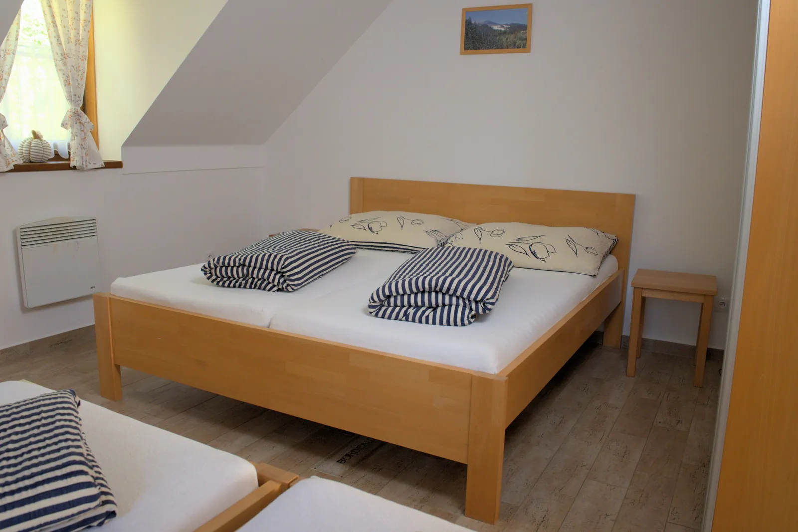 Manželská postel pod šikmým stropem v Apartmánu 3