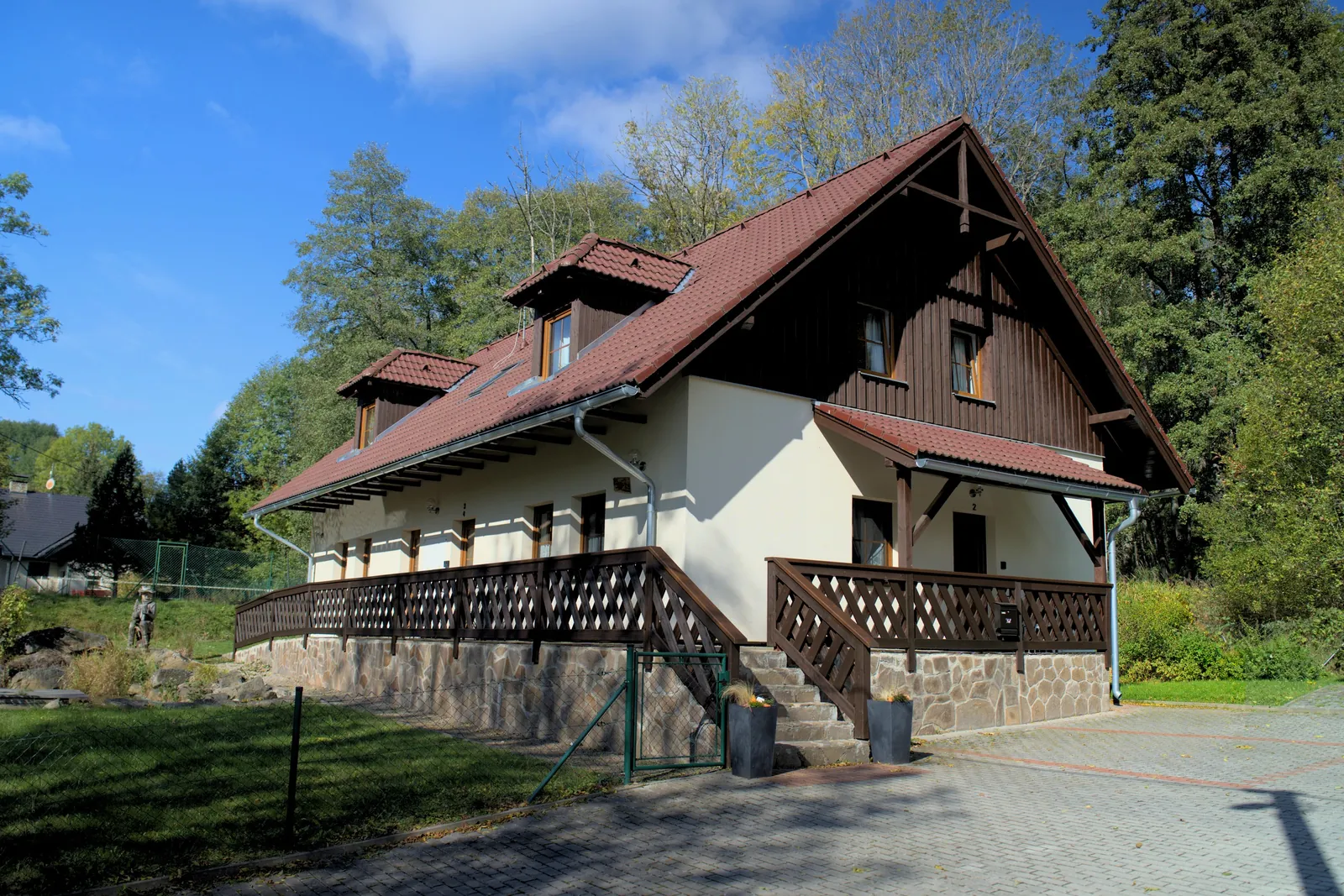 Dům od příjezdové cesty, terasa se schody ke vstupům